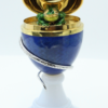 Een 18 kt gouden, geëmailleerd Fabergé ei, voorstelling van een kikker en een slang. Het gouden ei staat op een chalcedon voet. Tevens gezet met een briljant van 0.035 ct en een smaragd van 0.06 ct . Het object is gelimiteerd en genummerd 35/75  